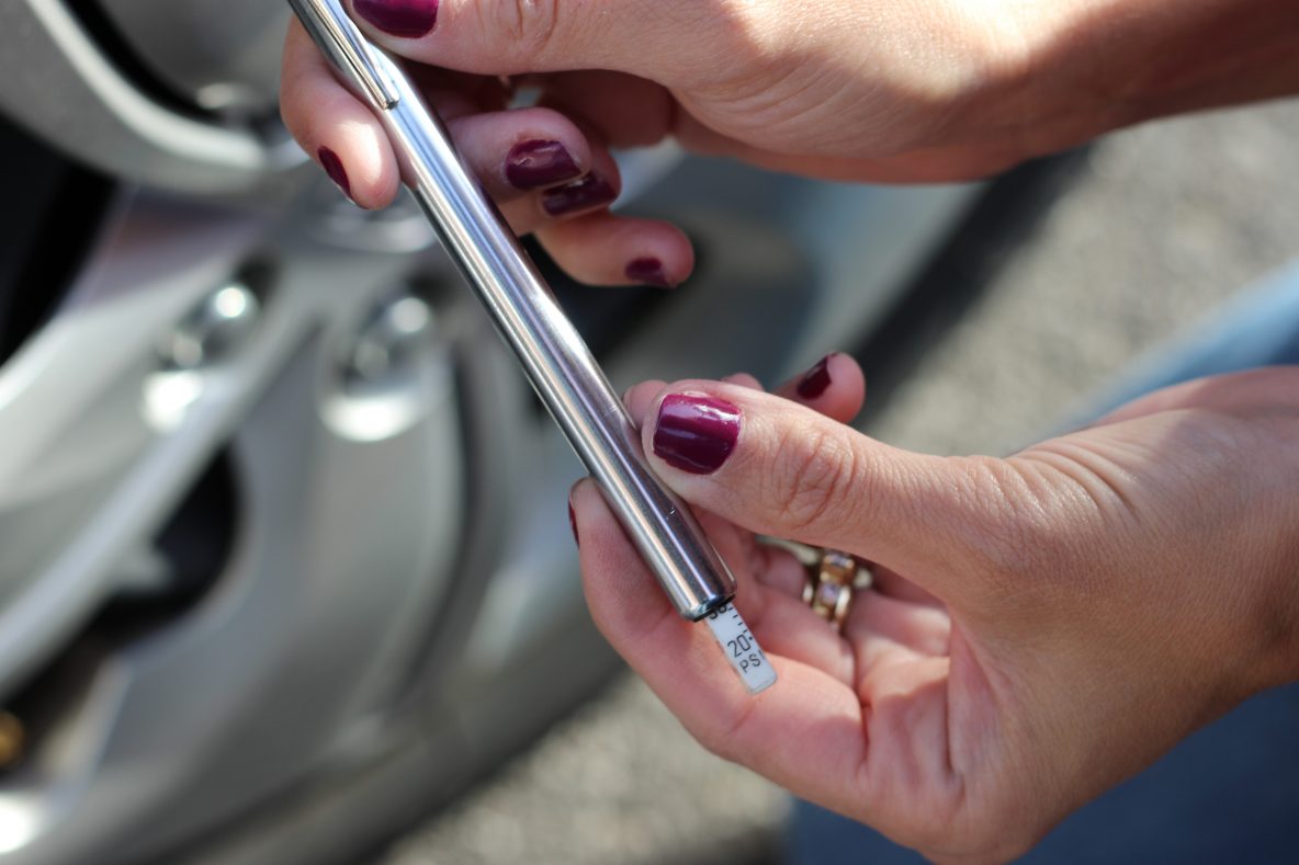 image of how to check tire pressure with a pressure gauge