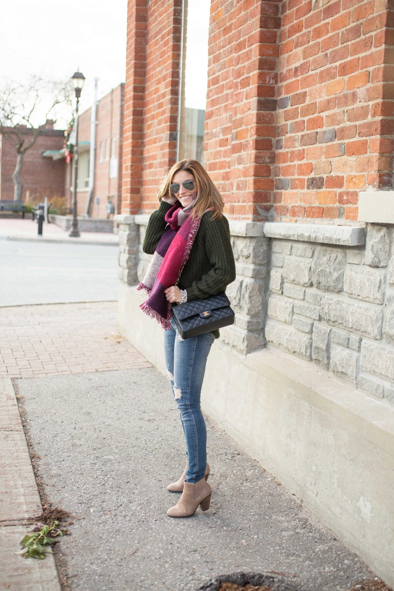 Oversized scarf with cable-knit sweater distressed jeans and Chanel bag