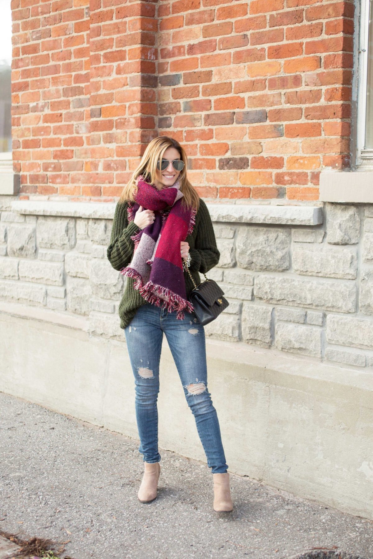 Oversized scarf with cable-knit sweater distressed jeans and Chanel bag