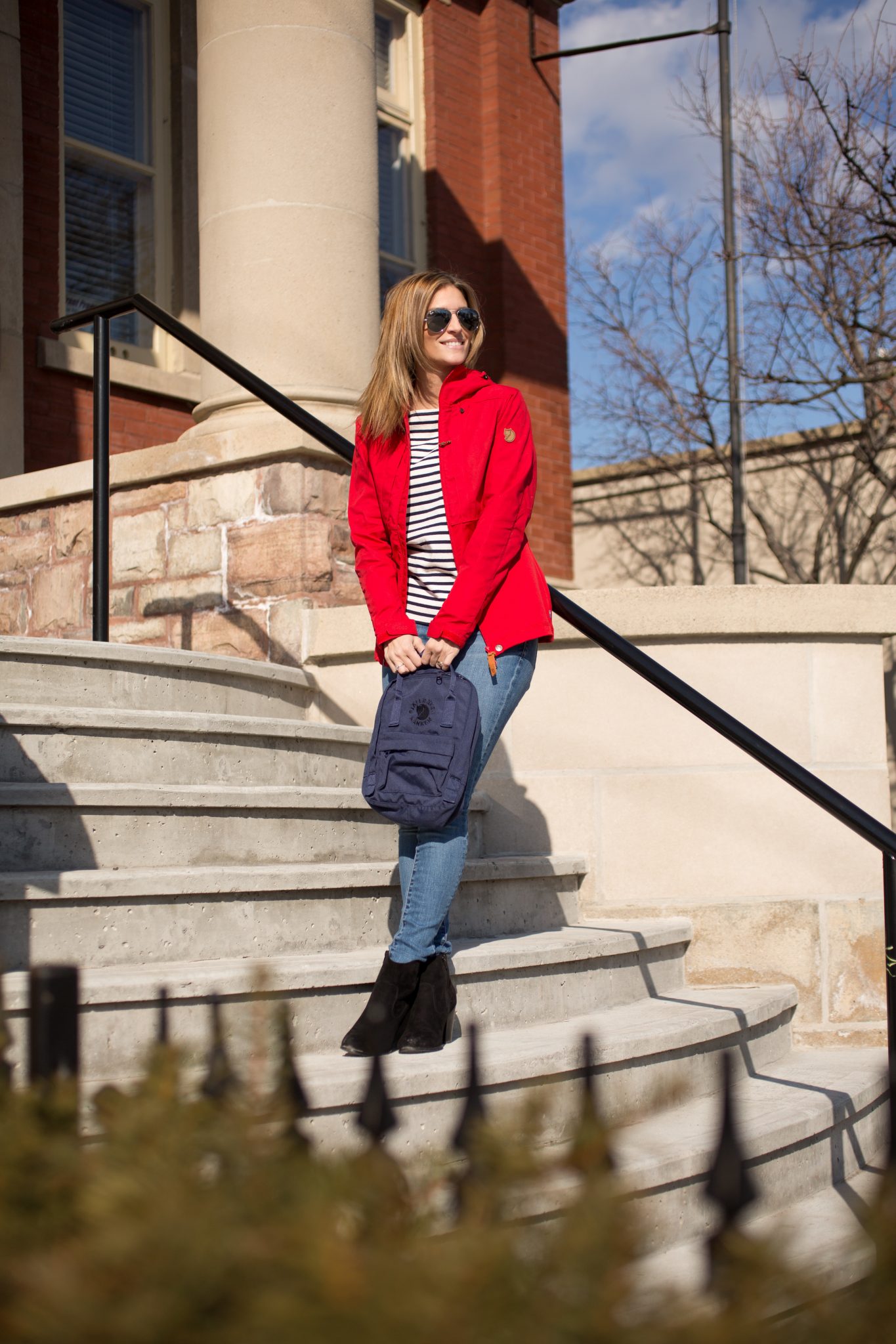 Abisko lite Jacket in red from Fjallraven Canada, re-kanken Mini backpack in navy, blue and white striped shirt from J.Crew, jean machine jeans, black suede booties