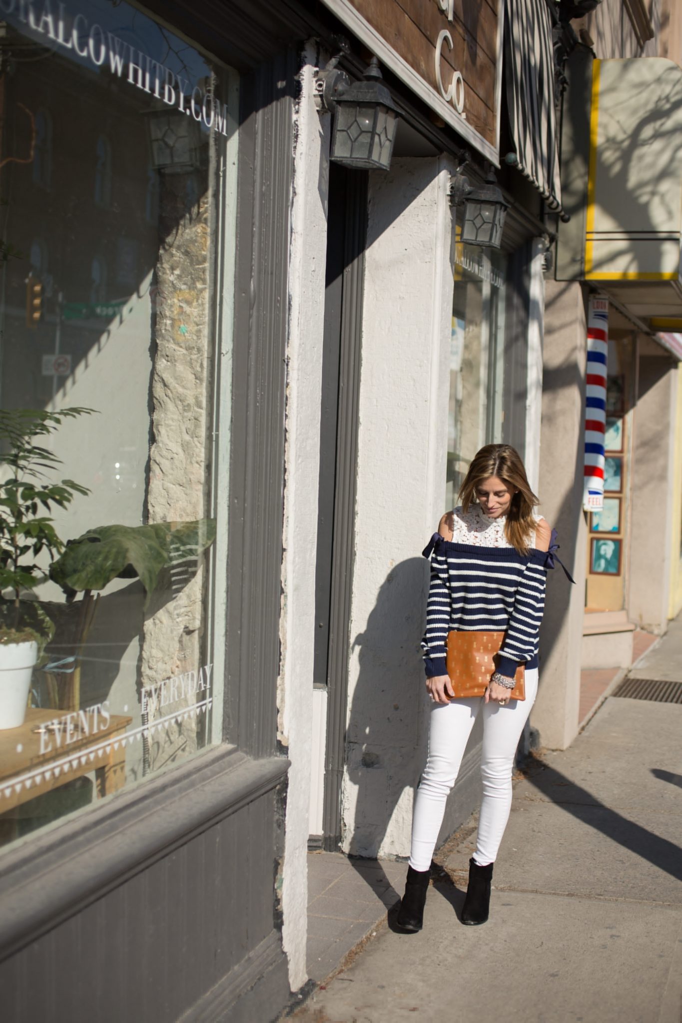 Chicwish Sweet Evocation Cold-shoulder Sweater in Navy Stripes, white jeans, black suede boots, pineapple clutch