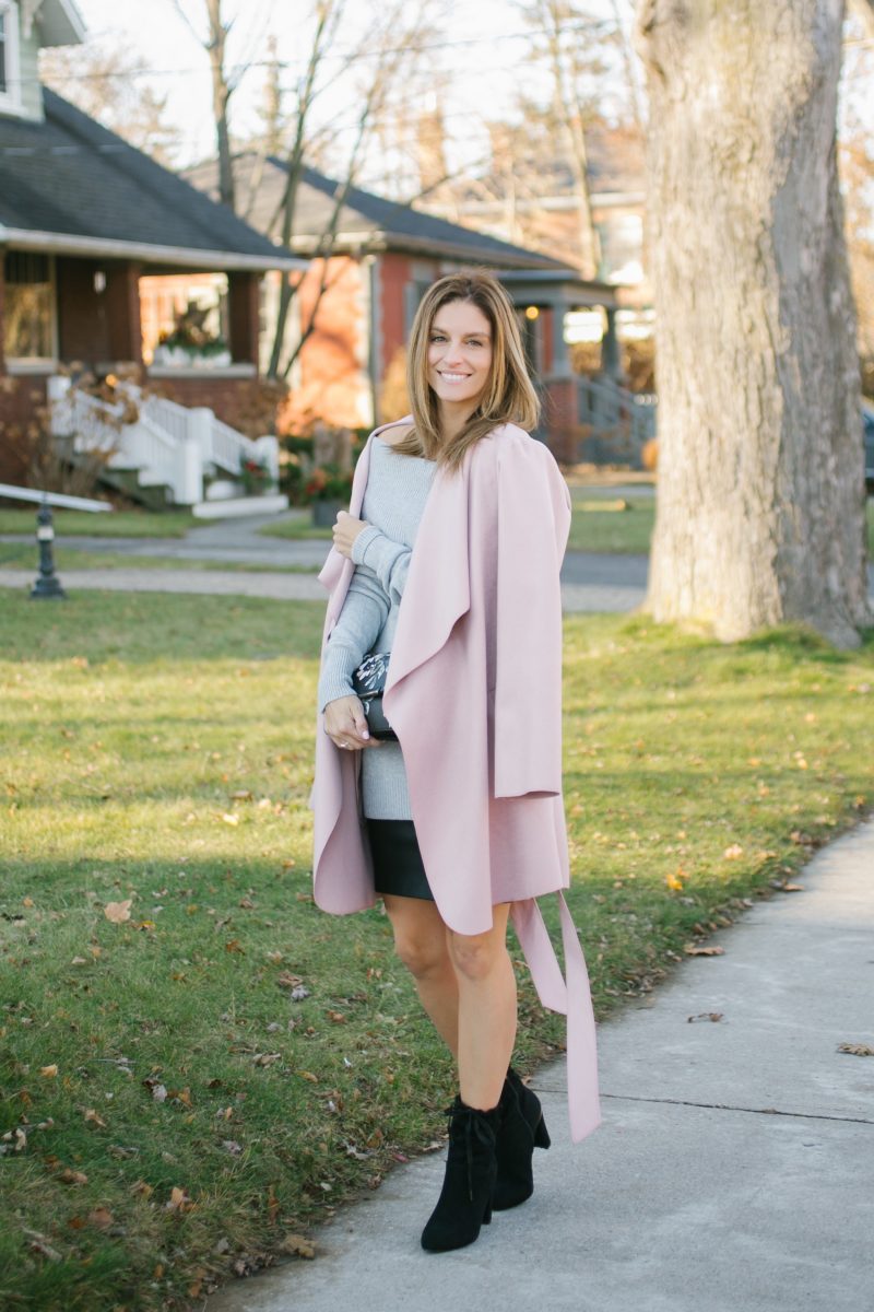Pink wrap coat; grey off the shoulder lace up sweater, leather skirt, floral clutch and suede booties le chateau